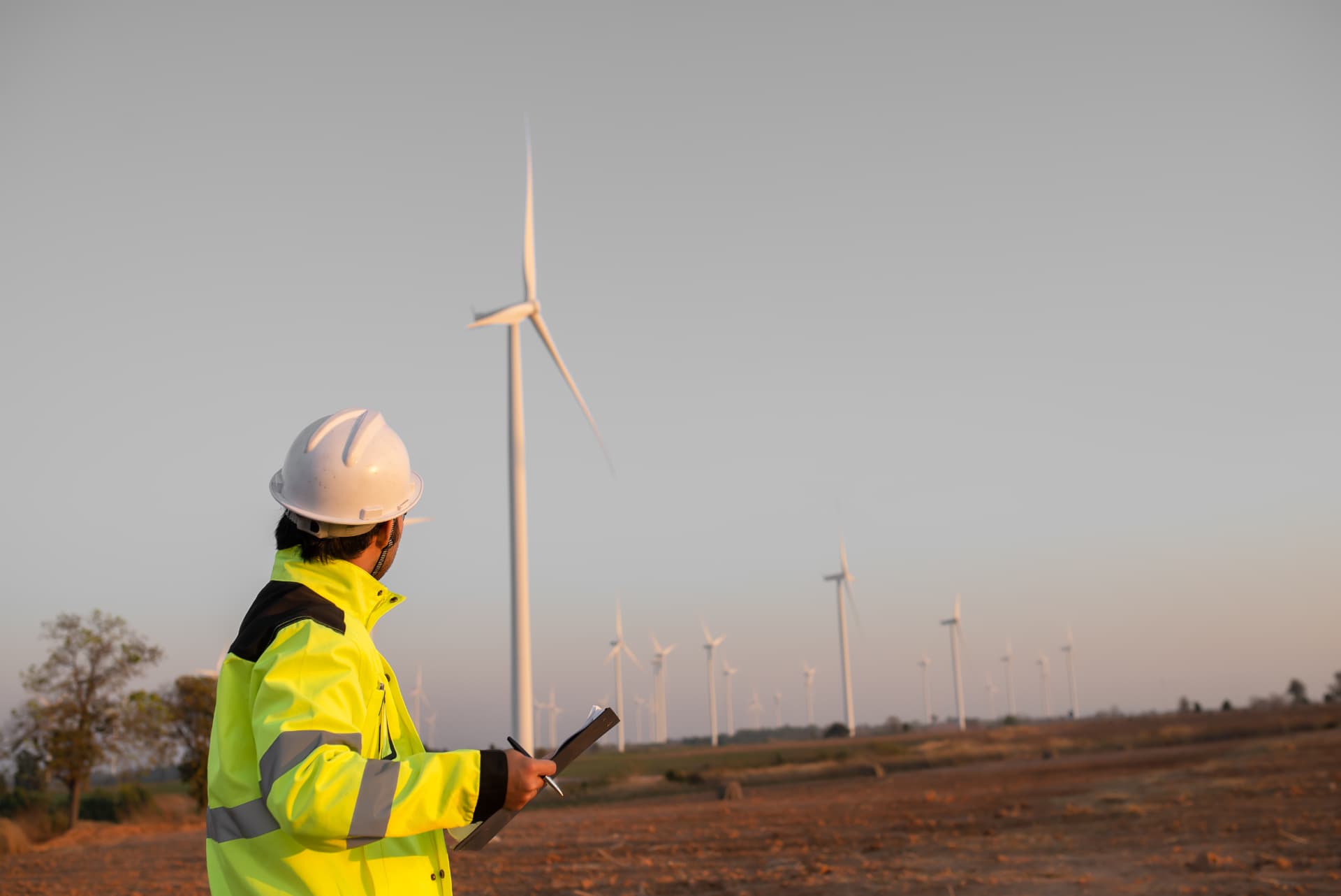 SPIE engineer inspecting a wind farm at dusk