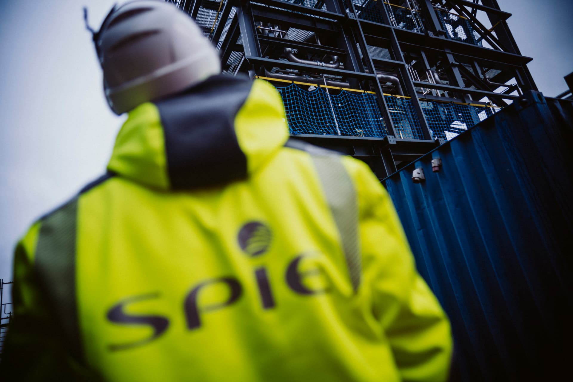SPIE worker in high-vis looking up at industrial plant structure